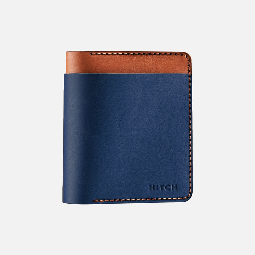 Blue and brown bi-fold leather wallet with stitching detail on white background.