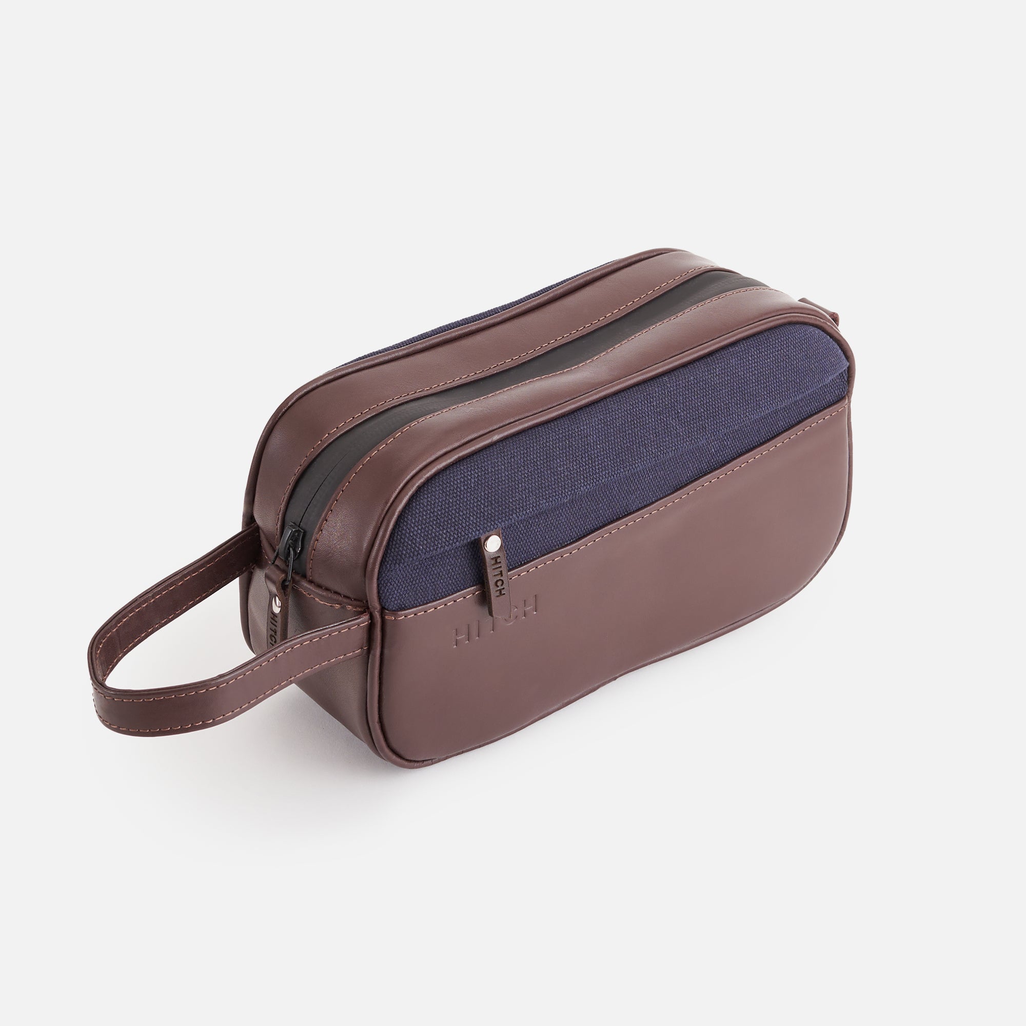 Brown and blue men's travel toiletry bag with wrist handle. embossed HITCH, on white background.