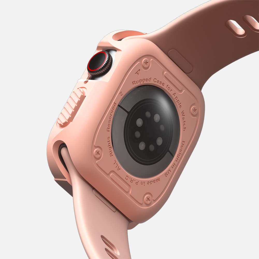 Close-up of rose gold smartwatch with rugged case and red digital crown focusing on the sensors and design.